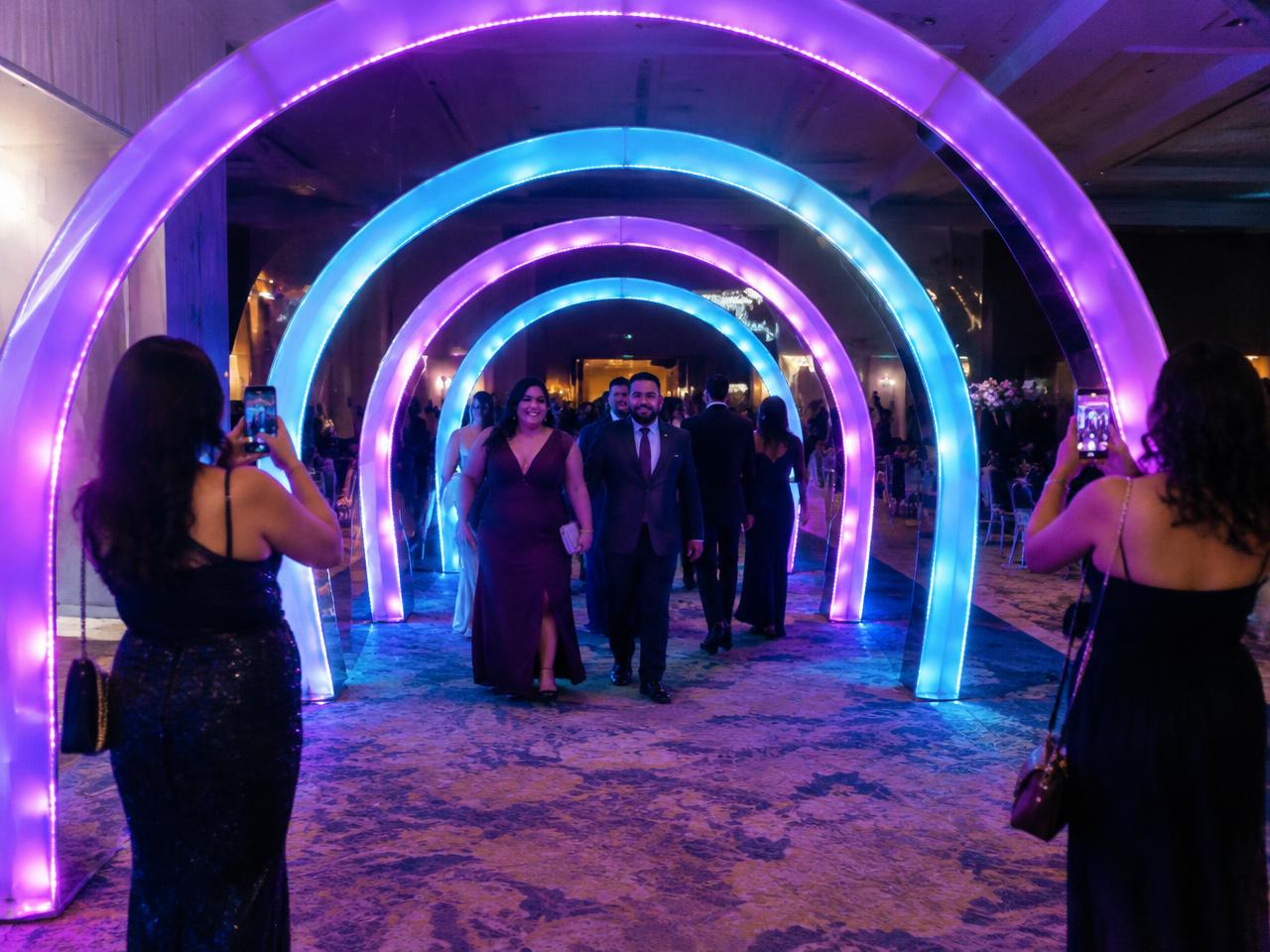 Guests walking through a glowing LED light tunnel at an event entrance